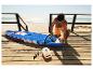 Homme gonflant une planche de paddleboard avec une pompe électrique sur la plage.
