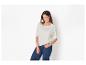 Femme en t-shirt blanc à boutons aux épaules et jean bleu foncé