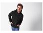 Lachende man in zwarte hoodie met rits en jeans.
