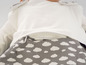 Een wit shirt met rits en een grijze broek met witte wolken.