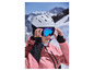 Een vrouw in een roze ski-jas, met een witte helm en blauwe ski-bril.