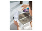 Een persoon giet Bissell multi-surface reinigingsmiddel in een fles.