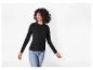 Een vrouw in een zwart T-shirt met lange mouwen en jeans lacht en kijkt opzij.