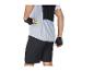 Cycliste en maillot de cyclisme gris clair avec un gel énergétique jaune dans la poche arrière et un short de cyclisme noir.