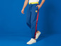 Een man draagt blauwe joggingbroeken met rode strepen en het Lidl logo.