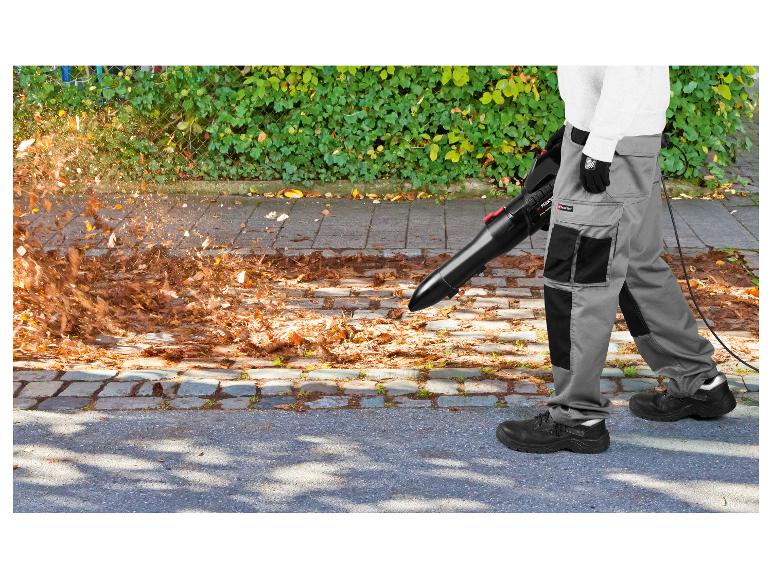 Man gebruikt een PARKSIDE elektrische bladblazer om bladeren op te ruimen.