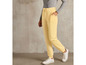 Pantalon de survêtement jaune avec des baskets blanches.
