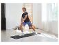 Homme faisant des étirements sur un tapis de sport, portant un t-shirt et un short de sport.