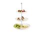 Présentoir à trois niveaux avec brochettes caprese, canapés au saumon, raisins et fromage