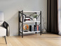 Een zwarte metalen boekenkast met witte planken, gevuld met boeken en decoratieve voorwerpen.