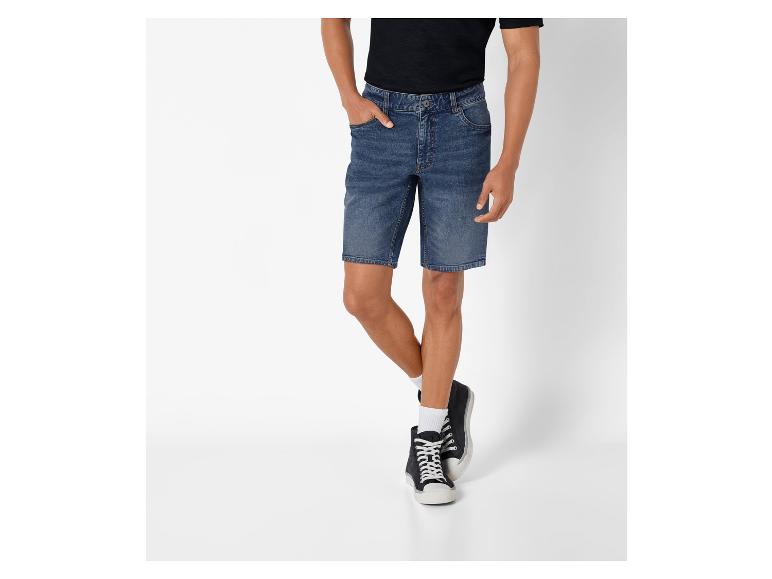 Man draagt een donkerblauwe spijkerbroek en zwarte sneakers.