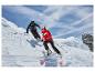 Deux skieurs en vestes et pantalons de ski, descendant une pente enneigée.