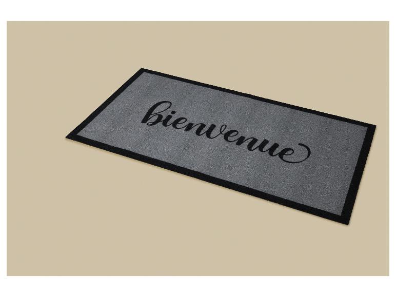 Paillasson gris avec le mot 'bienvenue' en écriture cursive noire.