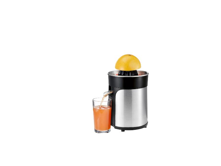Presse-agrumes en acier inoxydable avec jus de pamplemousse dans un verre