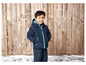 Un garçon portant une veste et un pantalon d'hiver bleus.