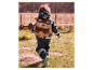 Enfant avec un sac à dos en forme de castor marchant dans un parc.