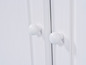 Twee witte knoppen op een witte houten kastdeur.