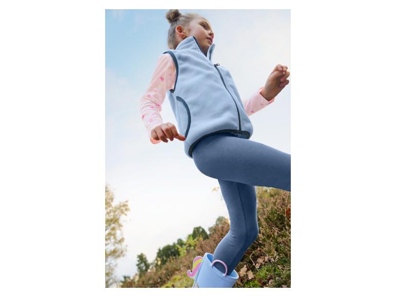 Fille en gilet polaire bleu clair, haut rose, legging bleu et bottes licorne