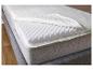 Un matelas avec un surmatelas en mousse et une housse grise.