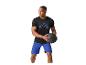 Homme en t-shirt noir et short bleu tenant un ballon de médecine noir.