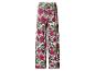 Damesbroek met wijde pijpen en tropisch patroon van roze bloemen en groene bladeren.