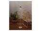 Une lampe de sol moderne illumine un patio avec une plante en pot et un fauteuil.