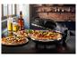 Pizza dans un four à pizza, deux pizzas sur des assiettes et de la bière sur une table.