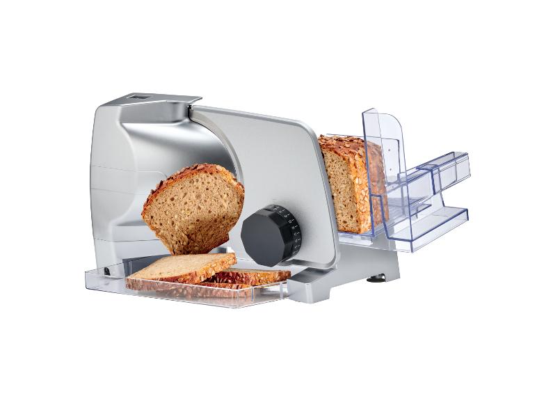 Zilveren elektrische broodsnijmachine met gesneden volkorenbrood.