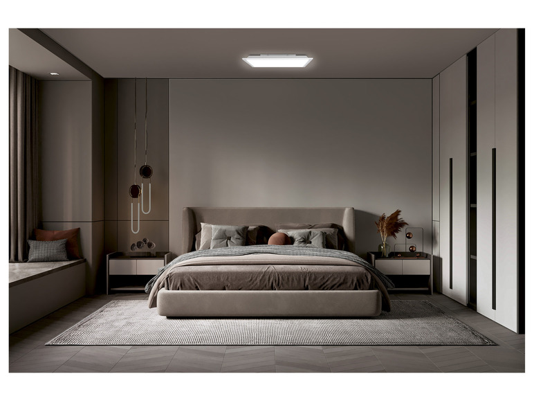 Een slaapkamer met een groot bed, twee nachtkastjes en een vloerkleed.