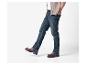 Un homme en jean foncé, t-shirt blanc et cardigan marron clair.