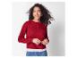 Vrouw in rode kabelgebreide trui, wit T-shirt en jeans.