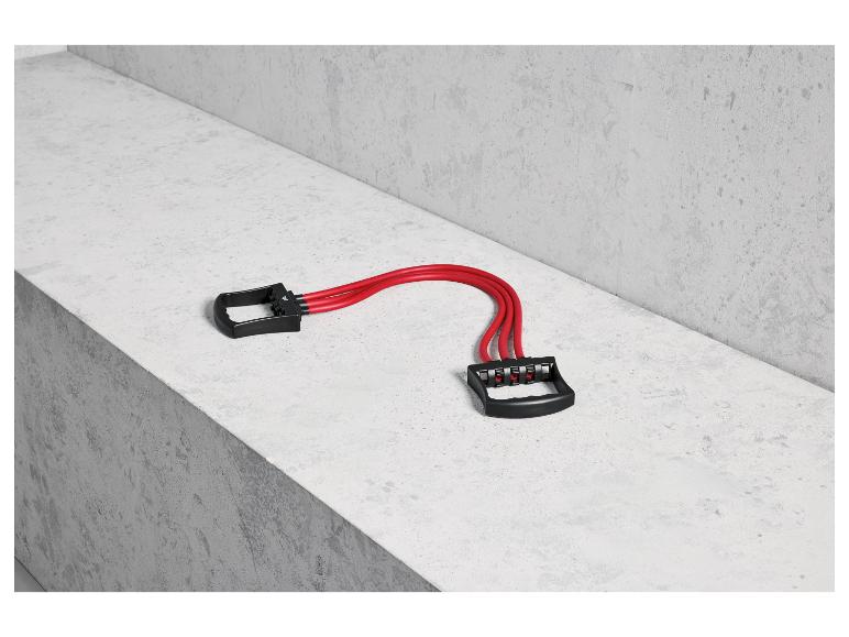 Rode fitness elastieken met handvatten op een betonnen oppervlak.