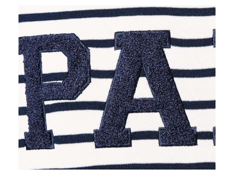Een detail van een wit gestreept shirt met de letters 'PA' in donkerblauw