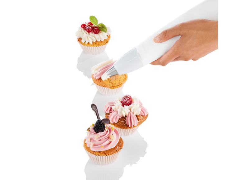 Een hand die slagroom spuiten op cupcakes