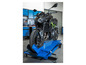 Une moto Kawasaki sur un pont élévateur hydraulique bleu.
