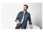 Mannelijk model in een jeans overhemd en een zwarte broek.