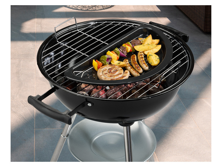 Een zwarte barbecue met een grillrooster en een pan om te bakken, met worsten en aardappelen.