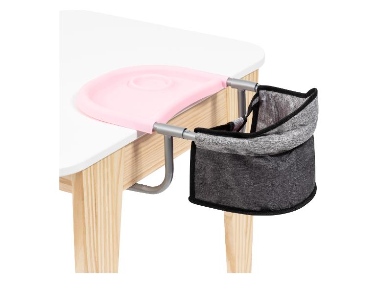 Une assiette rose pour bébé et une chaise grise pour bébé fixées à une table en bois.
