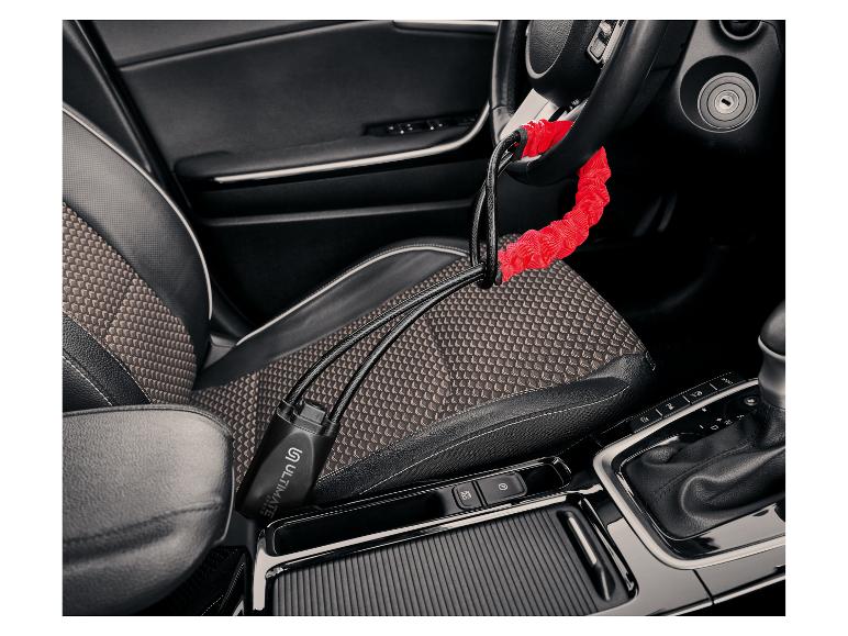 Câble antivol Ultimate Speed rouge et noir, fixé au volant d'une voiture.