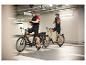 Twee elektrische fietsen en fietsers in een parkeergarage.