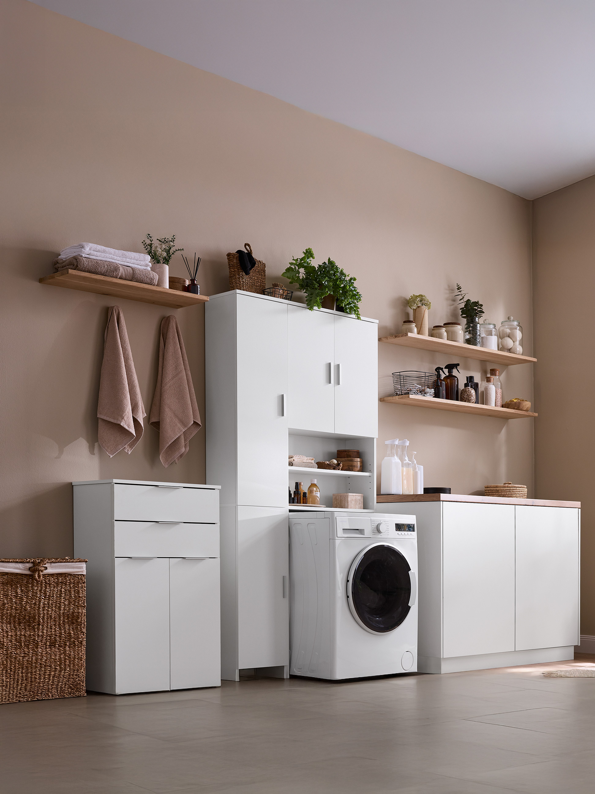 Buanderie moderne avec armoires blanches, étagères, machine à laver et panier en osier.