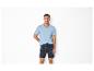 Man in lichtblauw V-hals T-shirt en bedrukte shorts.