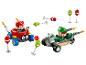 Deux voitures de course jouets avec figurines, rouge et verte, avec accessoires comme feux de signalisation et bombes.