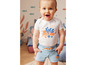 Bébé portant un body blanc avec un poulpe et un short en jean bleu.