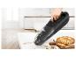 Aspirateur à main nettoyant les miettes de pain sur une table de cuisine.