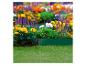 Jardin fleuri avec des fleurs jaunes, violettes et oranges, de l'herbe verte et une bordure.
