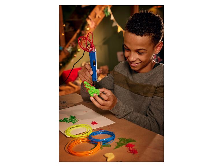 Un garçon utilisant un stylo 3D pour créer un sapin de Noël.
