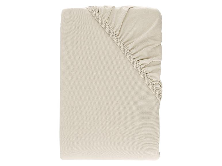 Beige hoeslaken met elastische hoeken, netjes opgevouwen.