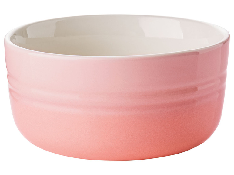 Een roze Le Creuset kom met een witte binnenkant.