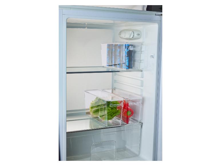 Binnenkant van een koelkast met transparante bakken gevuld met drankjes, sla en paprika.